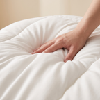 A hand pressing into the comforter to show the loft spring back
